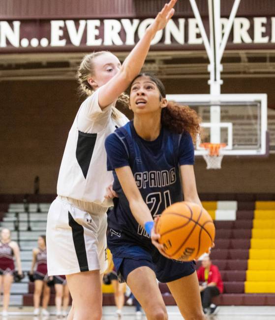 Spring Valley's high Charolette De Lisle (21) shoots for the basket as Faith Lutheran's Sami Mo ...