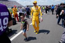 Kyle Busch walks with his son, Brexton, before a NASCAR Cup Series auto race Sunday, June 20, 2 ...