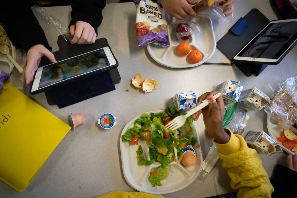 Seventh graders sit together in the cafeteria during their lunch break at a public school, Frid ...