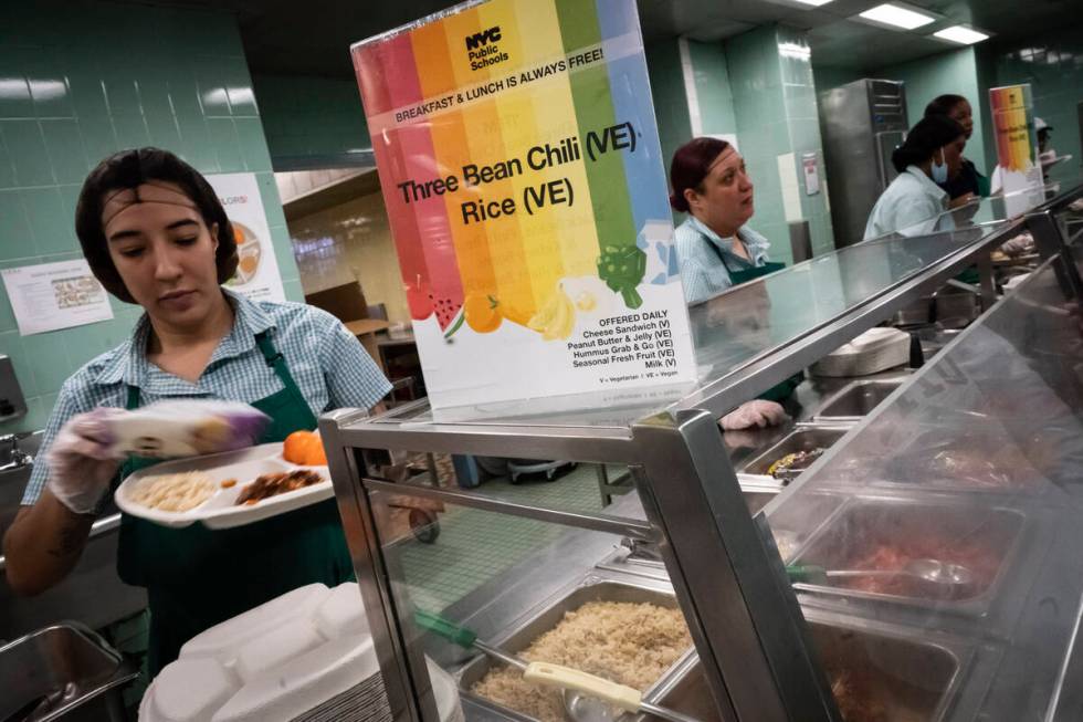 Cafeteria staff serve vegetarian and vegan options which include three-bean chili and rice to s ...