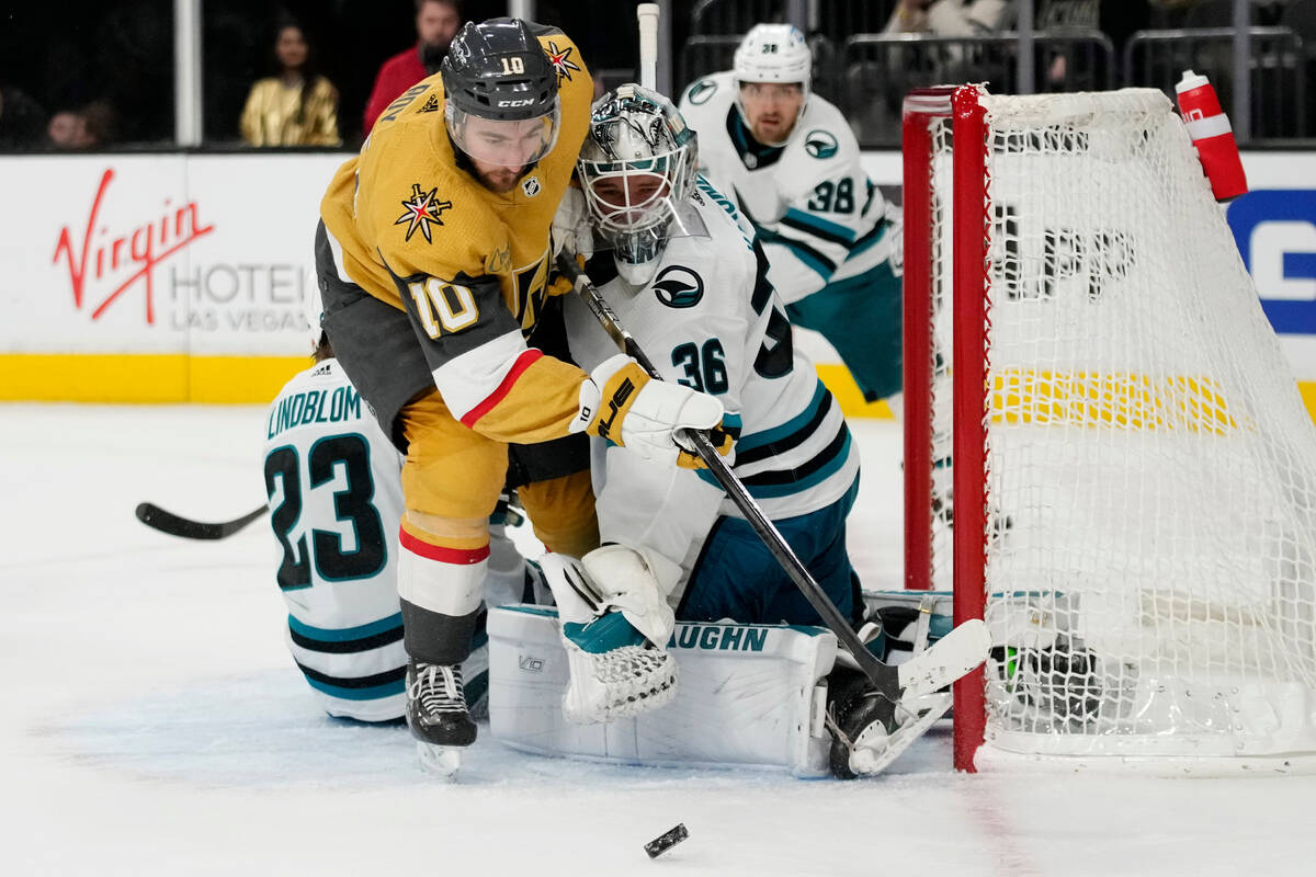 Vegas Golden Knights center Nicolas Roy (10) battle for the puck with San Jose Sharks goaltende ...