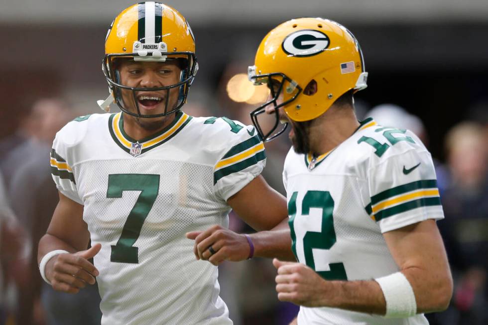 Green Bay Packers quarterback's Brett Hundley (7) runs with Aaron Rodgers (12) before an NFL fo ...