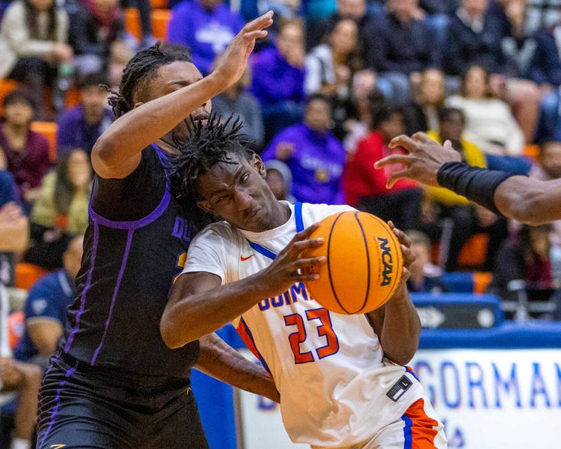 Bishop Gorman's Chris Nwuli (23) drives into Durango's Taj Degourville (24) on the way to the b ...