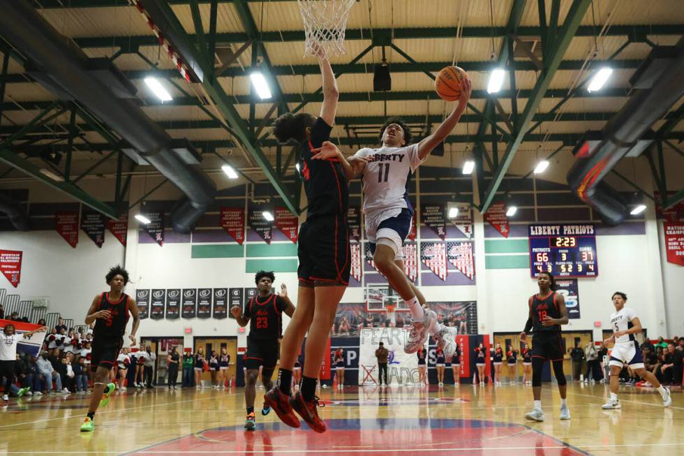 Liberty's Dedan Thomas (11) goes up for a shot under pressure from Coronado's JC Brooks (4) dur ...