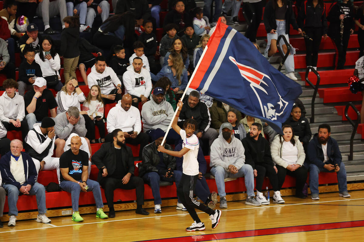 A fan waves a Patriots flag during a boys class 5A southern region semifinal game between Liber ...