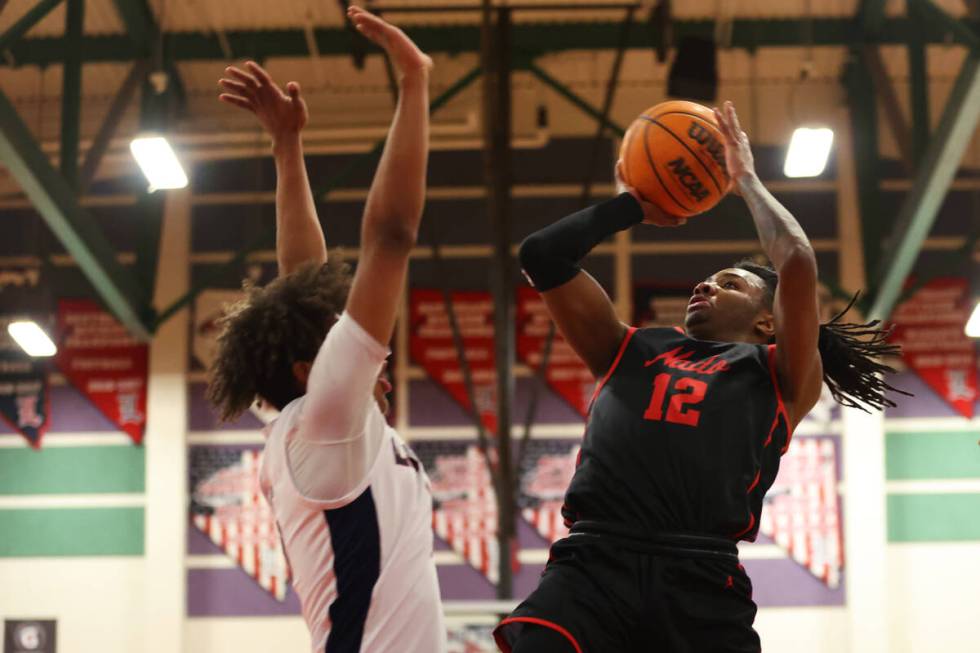 Coronado's Sebastian Mack (12) goes up for a shot under pressure from Liberty's Carlos Bradley ...