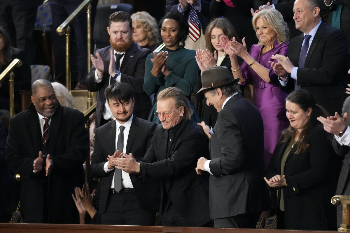 Bono, the Irish lead singer of U2, stands as he is recognized as President Joe Biden delivers t ...