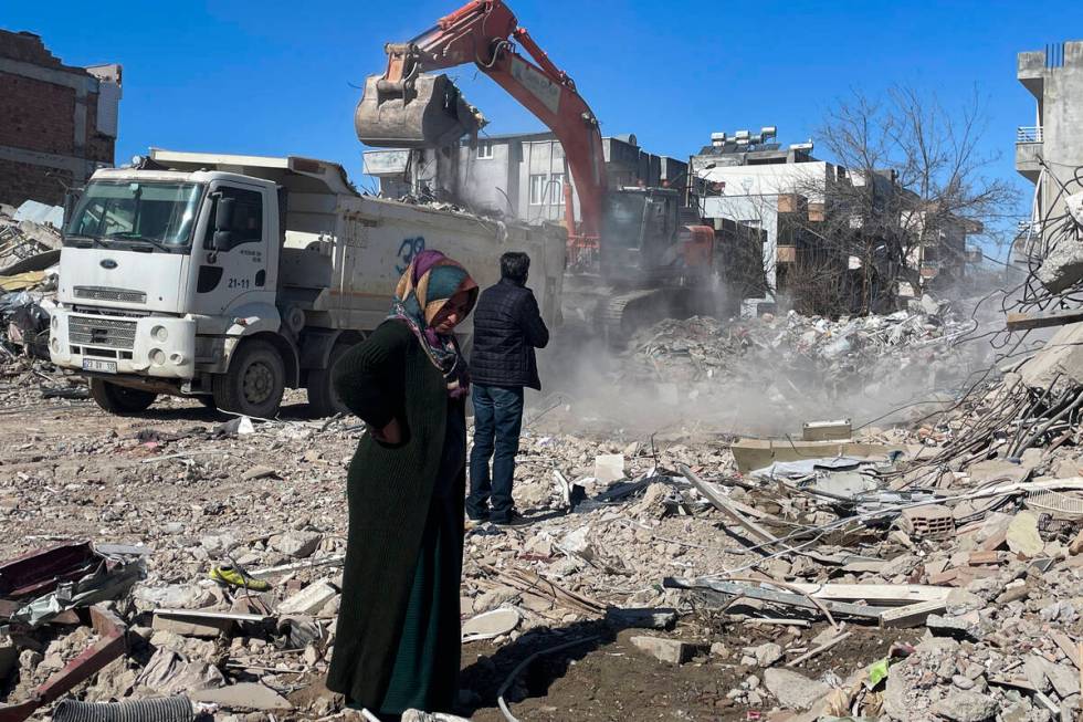 Parents of Taha Erdem, mother Zeliha Erdem, left, and father Ali Erdem stand next to the debris ...