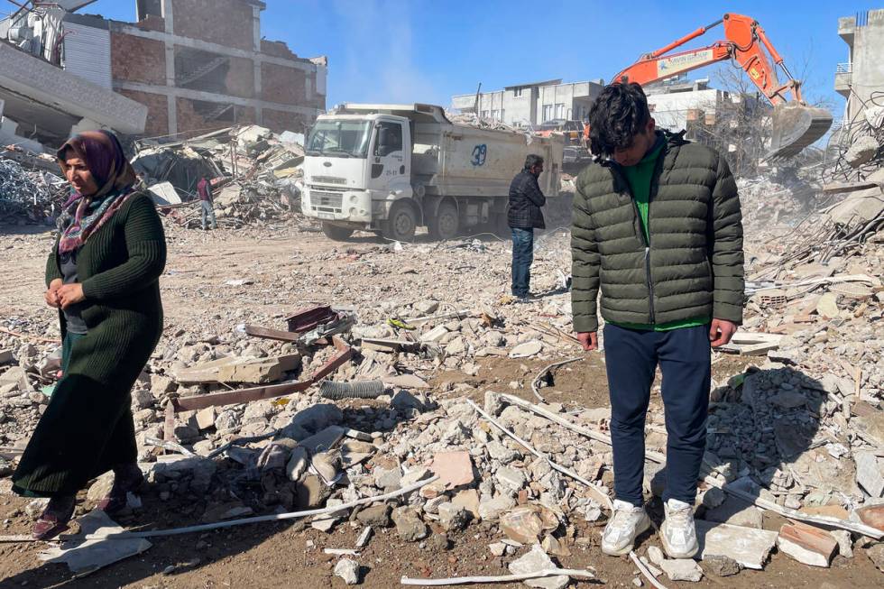 Taha Erdem, 17, right, his mother Zeliha Erdem, left, and father Ali Erdem stand next to the de ...