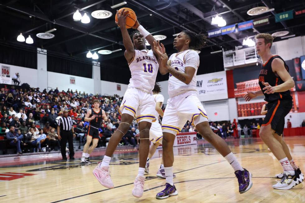 Durango's Tylen Riley (10), with Taj Degourville (24), grabs a rebound during a boys class 5A s ...