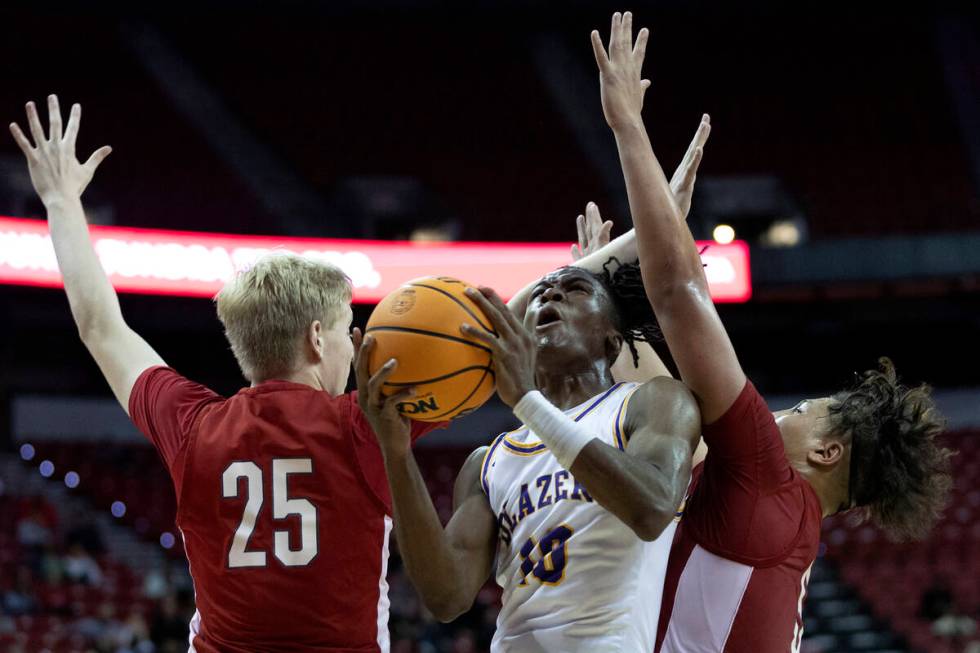 Durango’s Tylen Riley (10) shoots against Liberty’s Tyler Bright (25) and Andre P ...