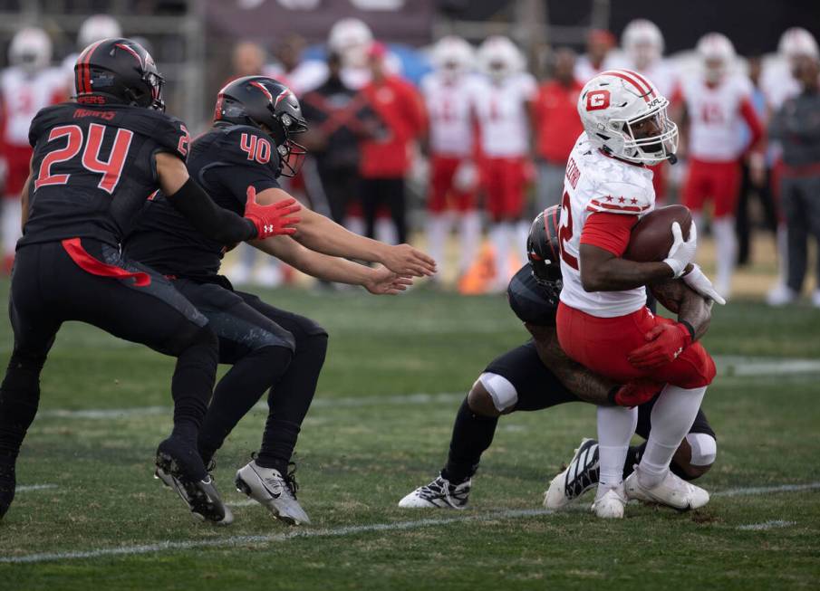 DC Defenders wide receiver Jaquez Ezzard is tackled as Vegas Vipers defenders Will Adams and Ad ...