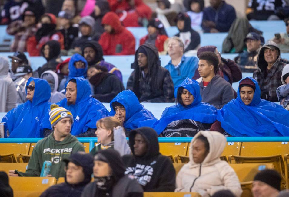 Fans cover up in rain jackets during the first half of an XFL football game between the Vegas V ...