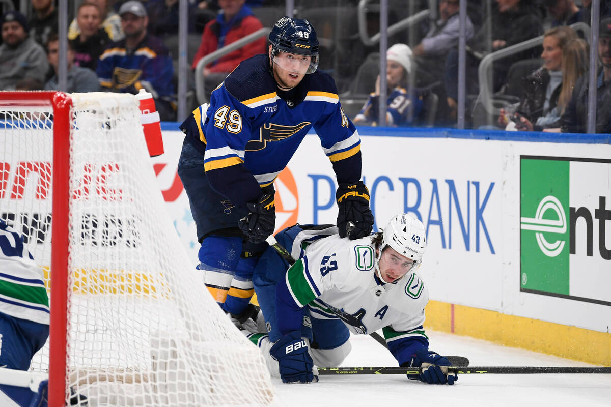 St. Louis Blues center Ivan Barbashev (49) battles Vancouver Canucks defenseman Quinn Hughes (4 ...