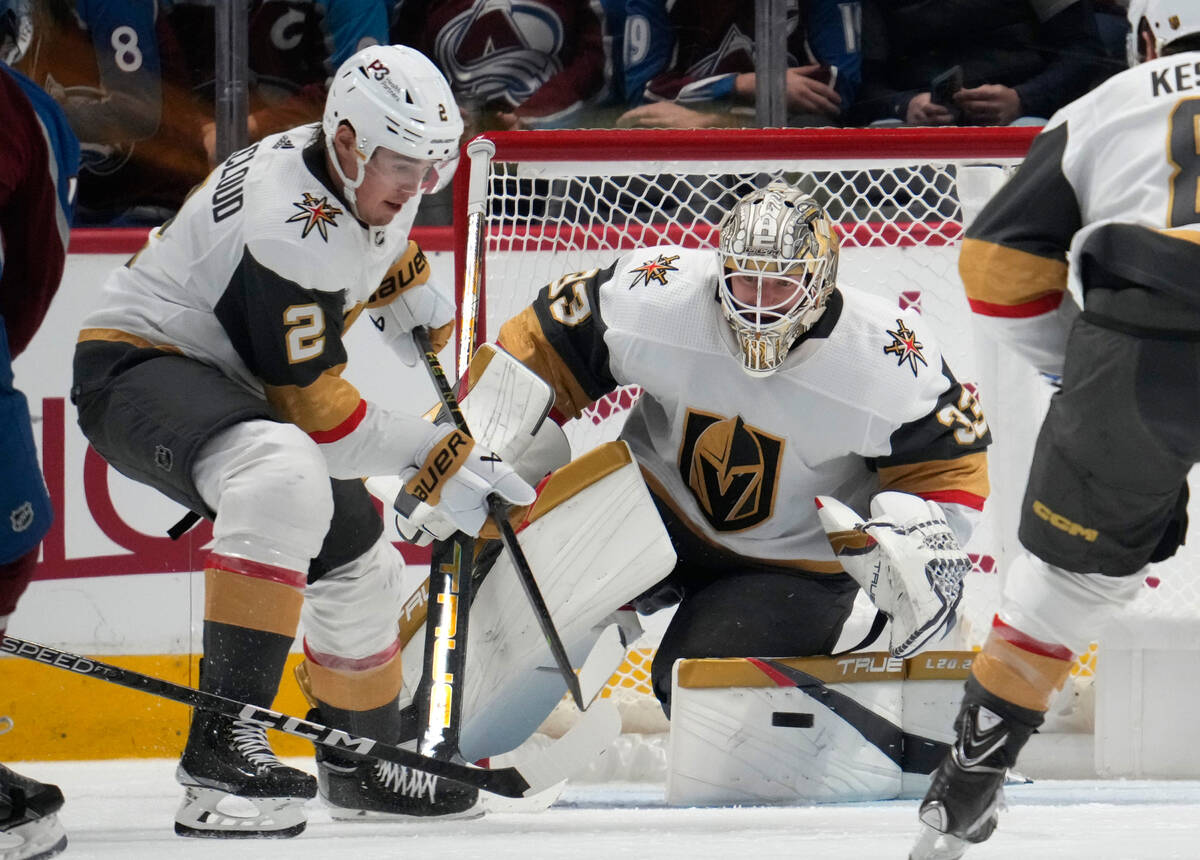 Vegas Golden Knights goaltender Adin Hill, right, stops a shot as defenseman Zach Whitecloud lo ...