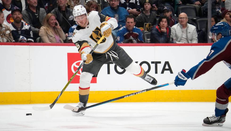 Vegas Golden Knights center Jack Eichel, left, shoots as Colorado Avalanche left wing J.T. Comp ...