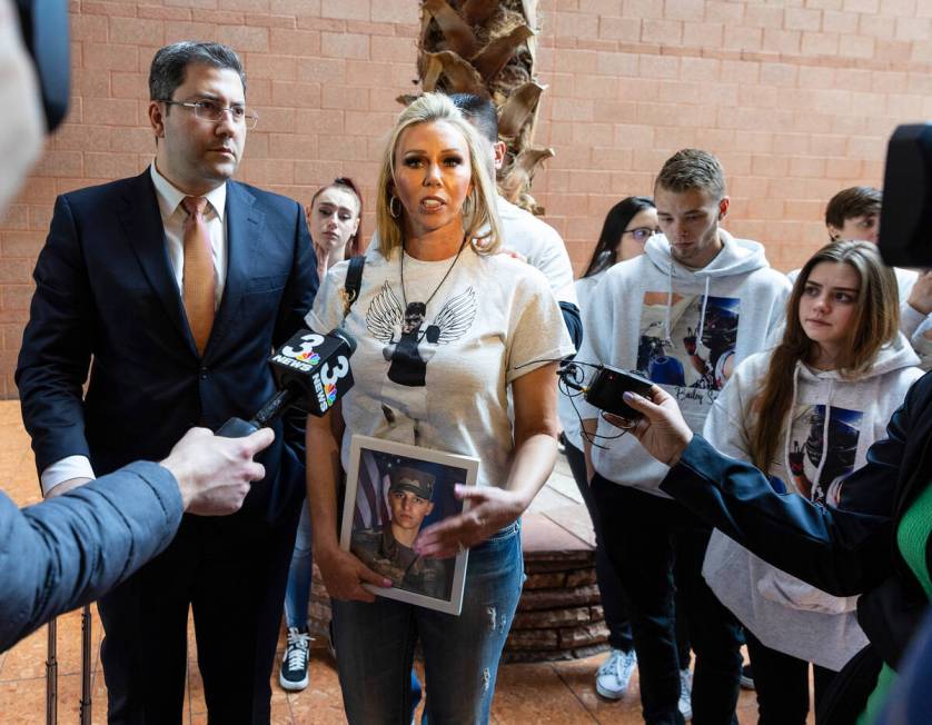 Kelli Norton, holds a photograph of her son Bailey Smith, a U.S. Army veteran, as she addresses ...