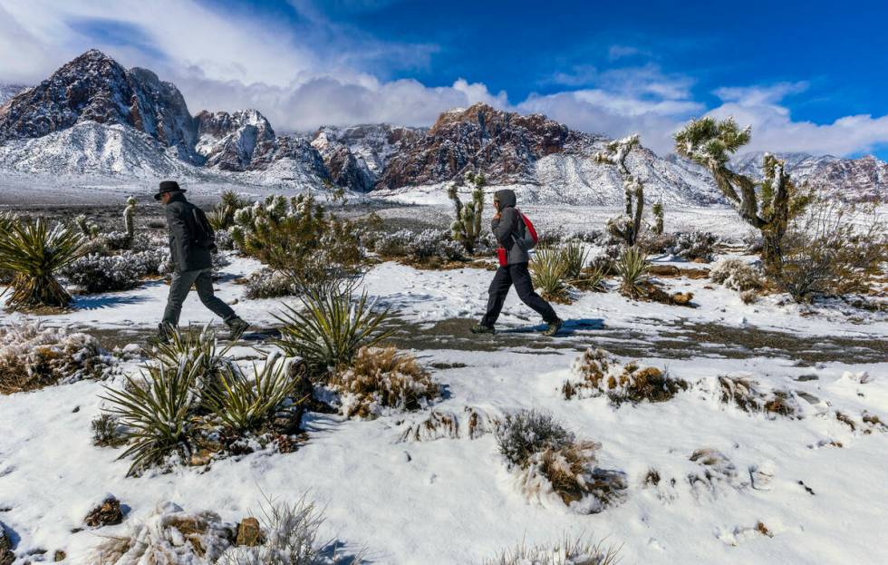 Visitors Andreas and Heidi Dornauf of Germany make their way down from a viewpoint ridge overlo ...