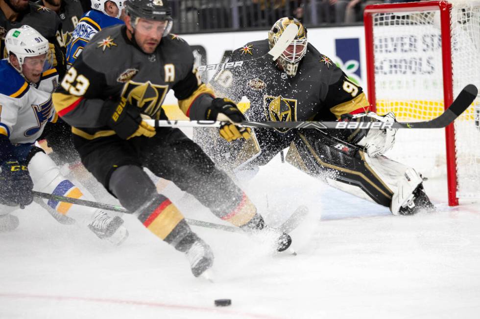 Golden Knights defenseman Alec Martinez (23) defends a shot on goaltender Robin Lehner (90) by ...