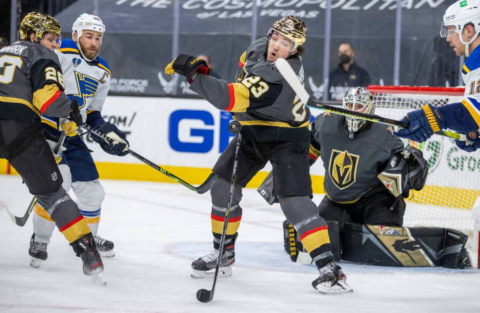 Golden Knights defenseman Alec Martinez (23) slaps a puck down with St. Louis Blues left wing Z ...