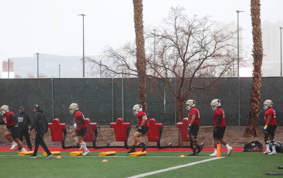 Members of UNLV’s offensive line run through drills during the first day of spring footb ...