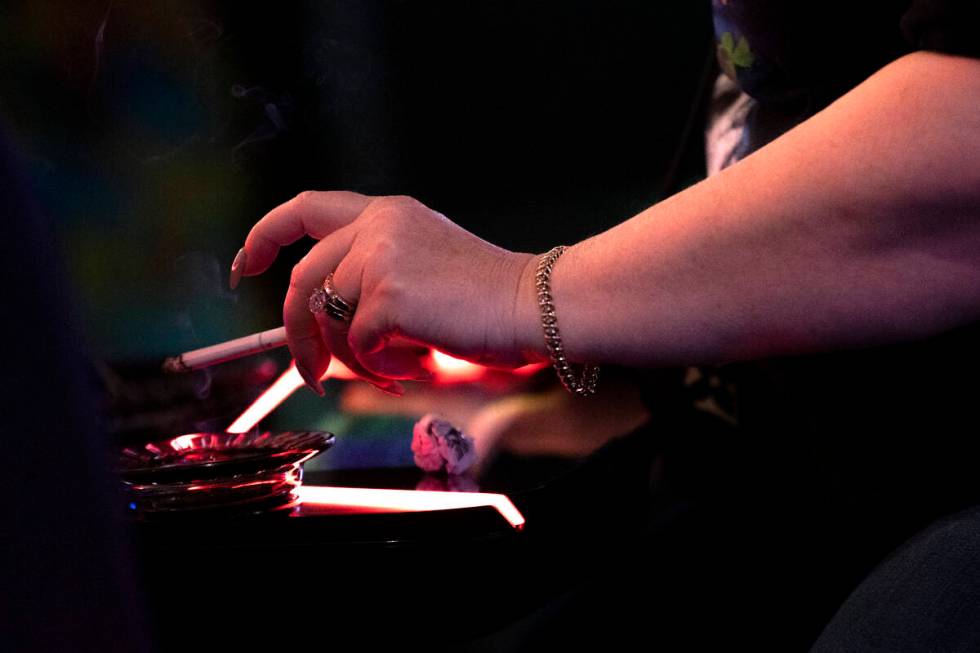 A guest at The Plaza smokes a cigarette while gambling on Thursday, March 2, 2023, in Las Vegas ...