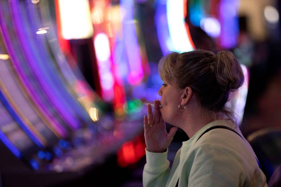 Linda, who declined to give her last name, smokes a cigarette while playing a game at The Plaza ...