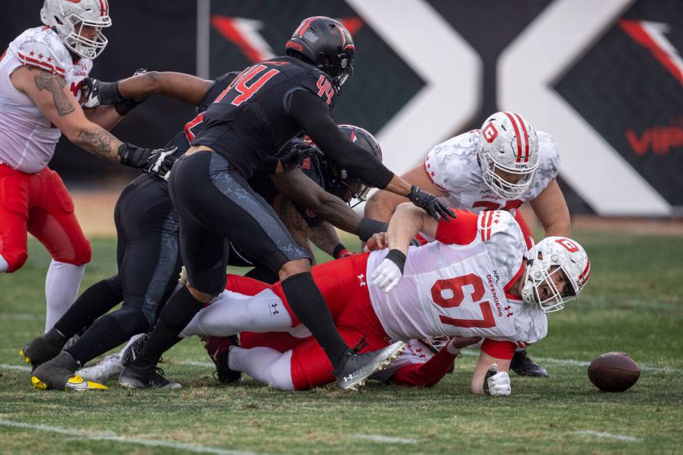 Vegas Vipers defender Vic Beasley pursues a fumble as DC Defenders Cody Conway falls to the gro ...