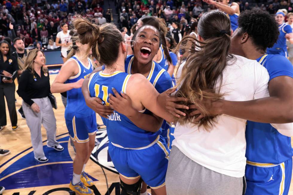 UCLA guard Charisma Osborne, center, celebrates with forward Emily Bessoir (11) after the team' ...