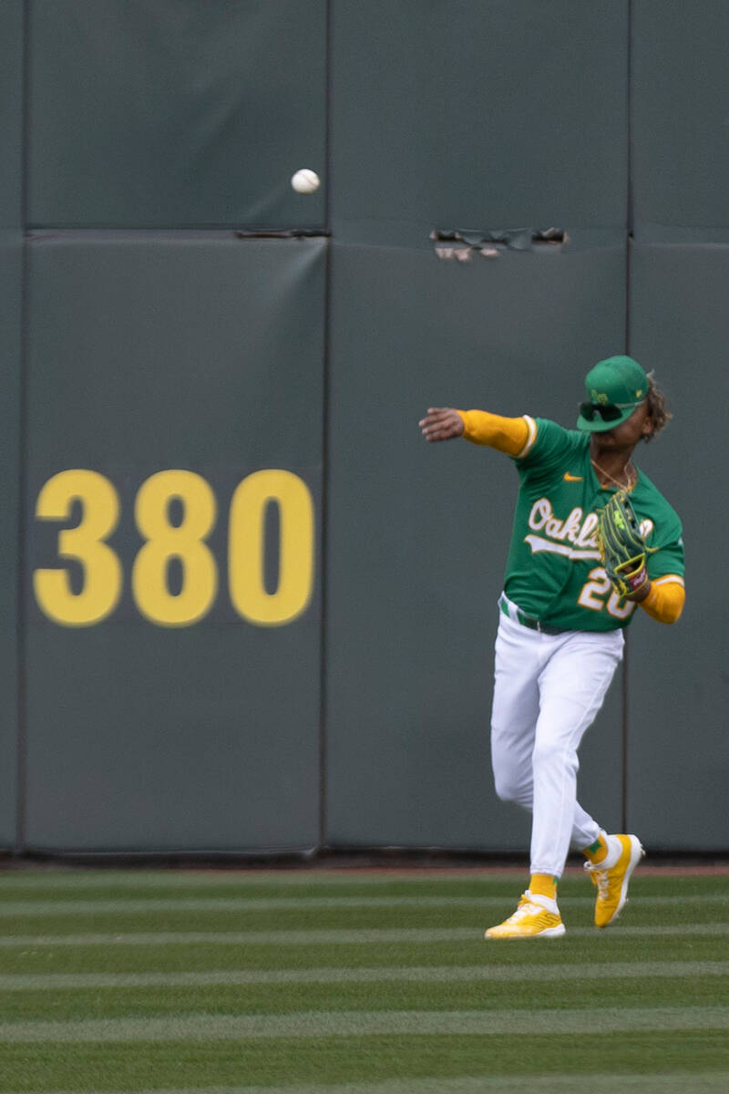 Oakland Athletics center fielder Cristian Pache (20) makes a throw during the first inning of a ...