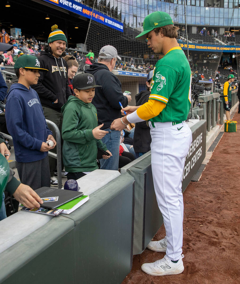 Oakland Athletics shortstop Max Muncy (81) signs an item for 11-year-old Ethan Gonzales of Las ...