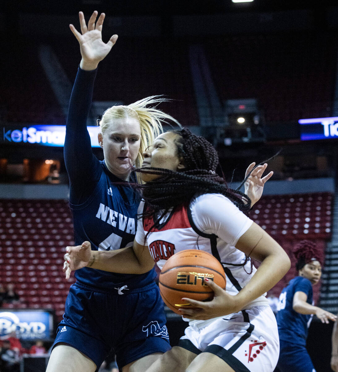 UNLV Lady Rebels forward Alyssa Brown (44) drives ton the basket as Nevada Wolf Pack forward Me ...