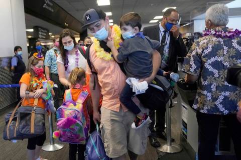 In this Oct. 15, 2020 file photo, Hawaii resident Ryan Sidlow carries his son Maxwell as their ...