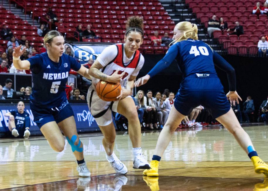 UNLV Lady Rebels guard Essence Booker (24) drives between Nevada Wolf Pack guard Kaylee Borden ...