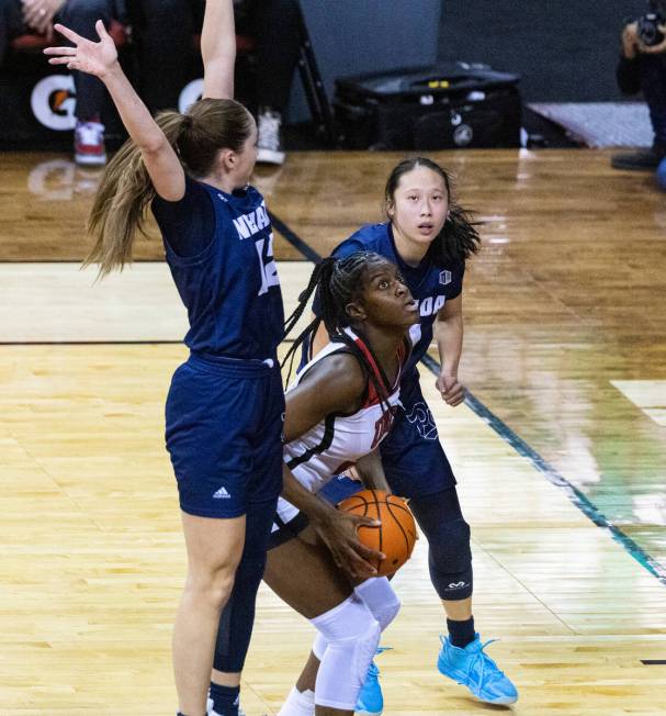 UNLV Lady Rebels center Desi-Rae Young (23) tries to shoot for the basket as Nevada Wolf Pack g ...