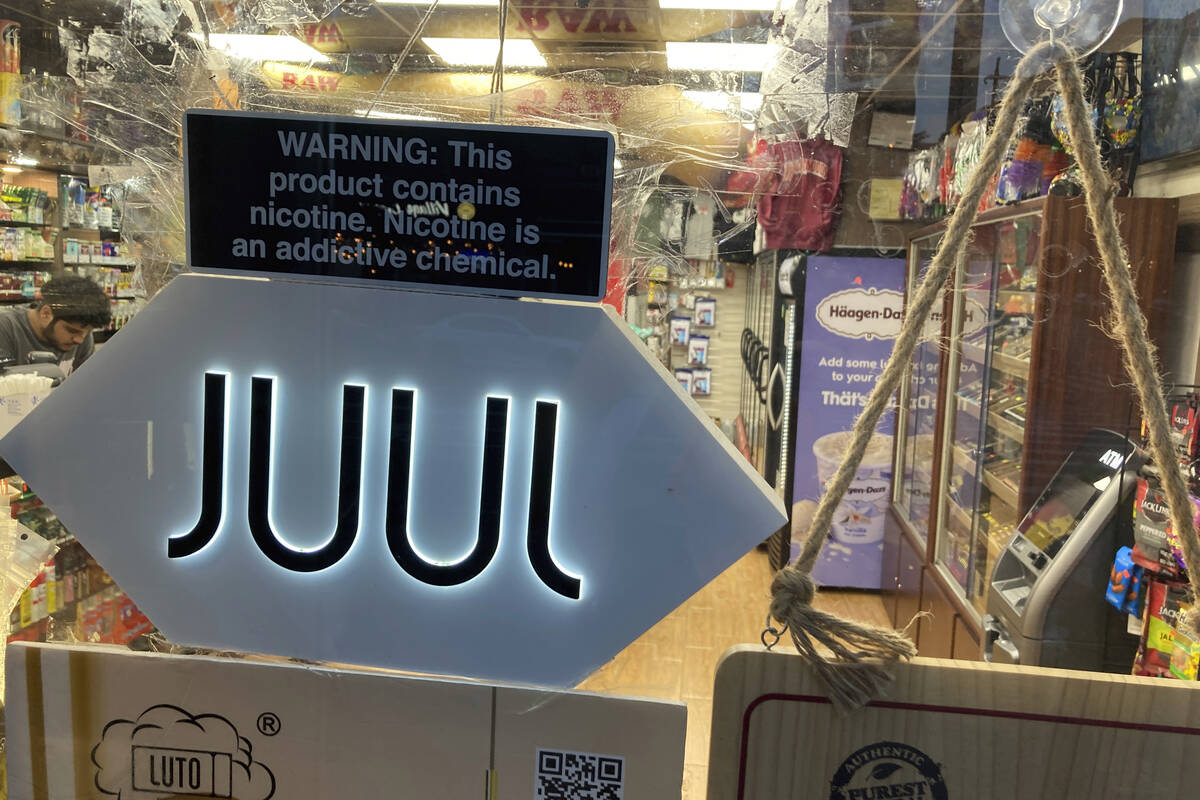 A Juul electronic cigarette sign hangs in the front window of a bodega convenience store in New ...