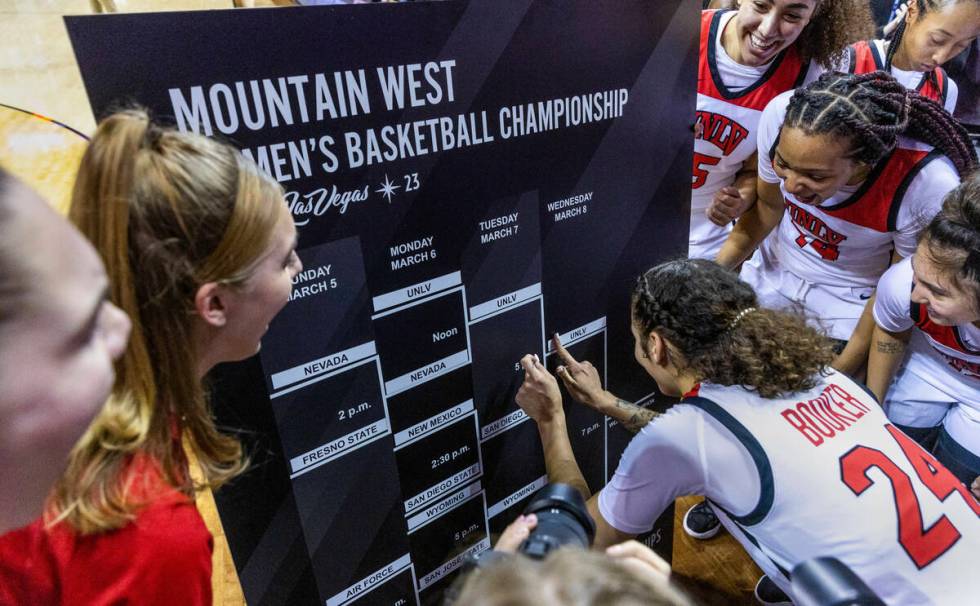 UNLV guard Essence Booker (24) puts a winning sticker on a bracket board as teammates cheer aft ...