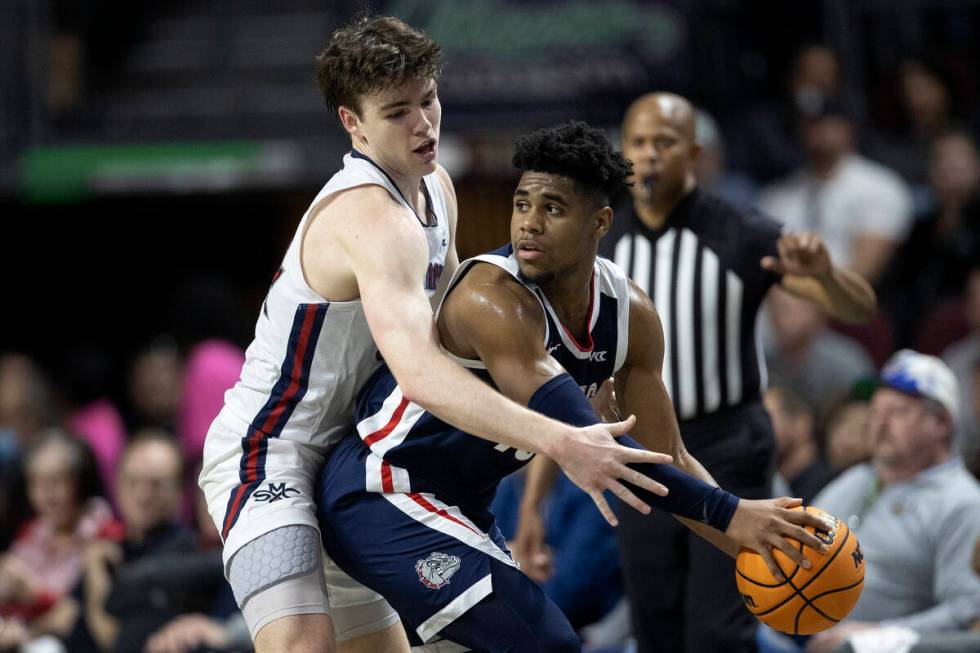 Gonzaga Bulldogs guard Malachi Smith, right, looks to pass around St. Mary's Gaels guard Alex D ...