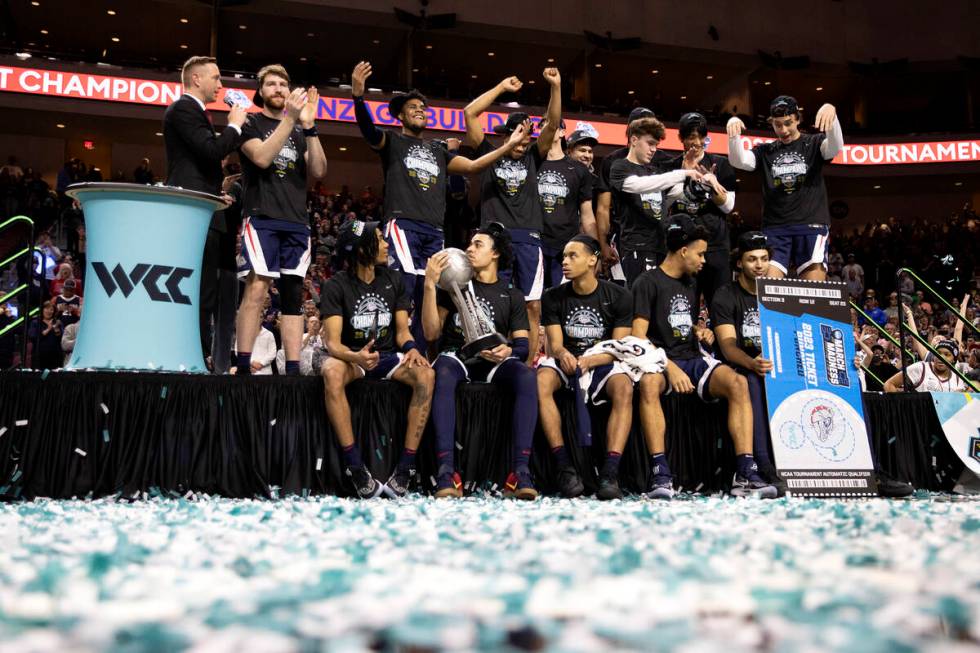 The Gonzaga Bulldogs cheer and pose for photos after winning a West Coast Conference men&#x2019 ...