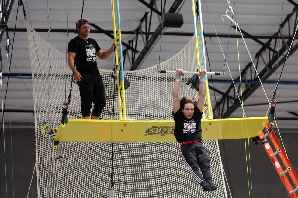 Henderson Farfan, 18, right, shows off his trapeze skills while his uncle Victor Galvis looks o ...