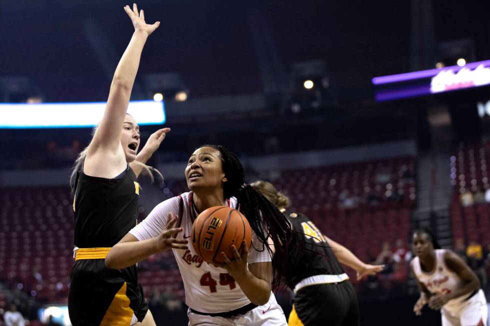 UNLV Lady Rebels forward Alyssa Brown (44) drives to shoot around Wyoming Cowgirls forward Grac ...