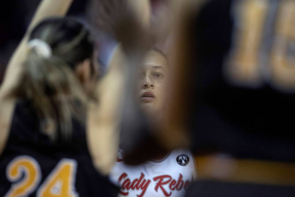 UNLV Lady Rebels guard Kiara Jackson, center, looks for a way to the basket between the Wyoming ...