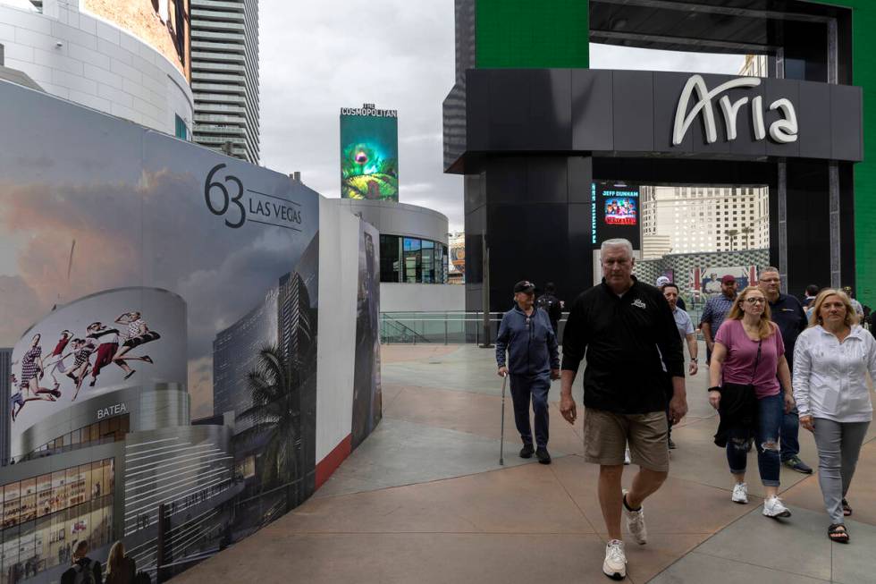 Pedestrians pass signs for 63, a new retail complex at the intersection of Las Vegas Boulevard ...