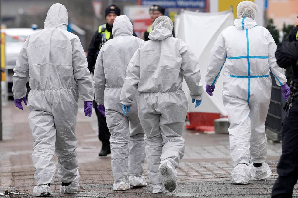 Forensic experts walk to a Jehovah's Witness building in Hamburg, Germany, on Friday, March 10, ...