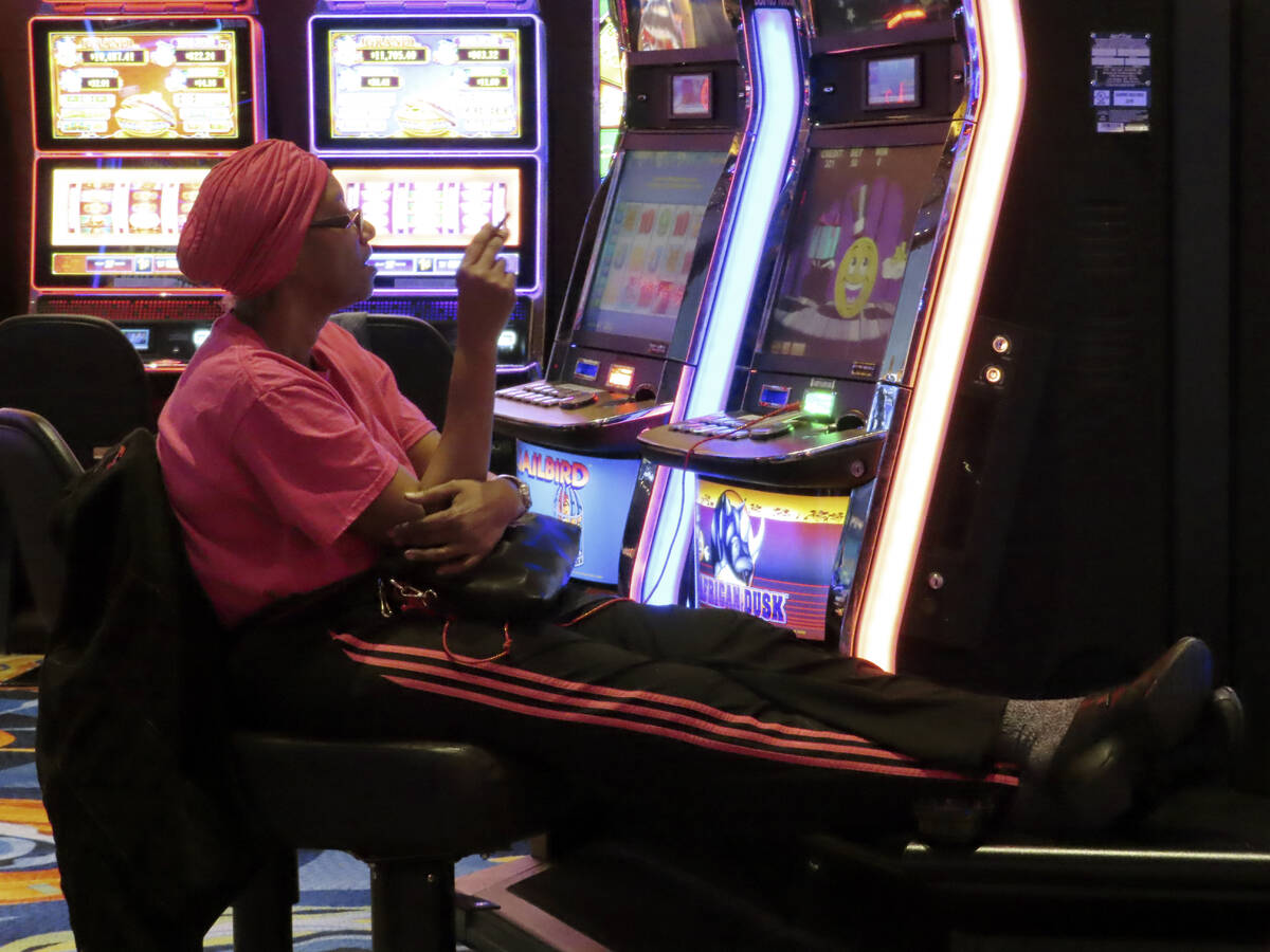 A gambler plays a slot machine while smoking in the Ocean Casino Resort in Atlantic City N.J. o ...