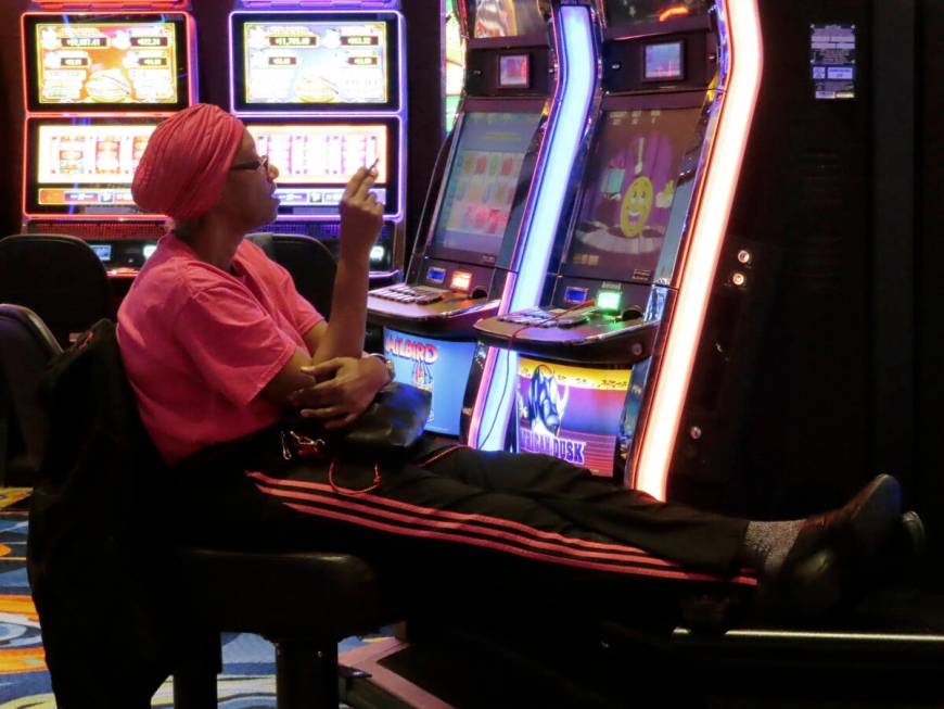 A gambler plays a slot machine while smoking in the Ocean Casino Resort in Atlantic City N.J. o ...