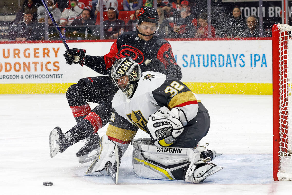 Carolina Hurricanes' Jesperi Kotkaniemi (82) collides with Vegas Golden Knights goaltender Jona ...