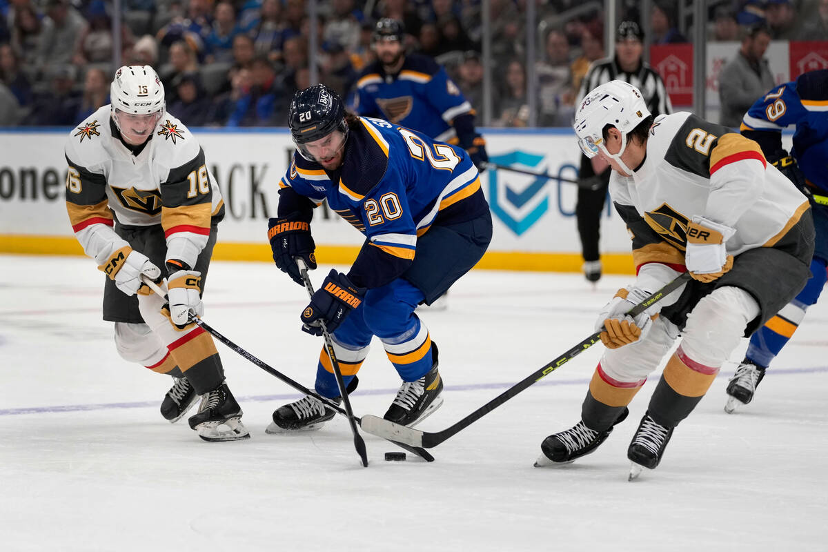 St. Louis Blues' Brandon Saad (20) reaches for a puck between Vegas Golden Knights' Pavel Dorof ...