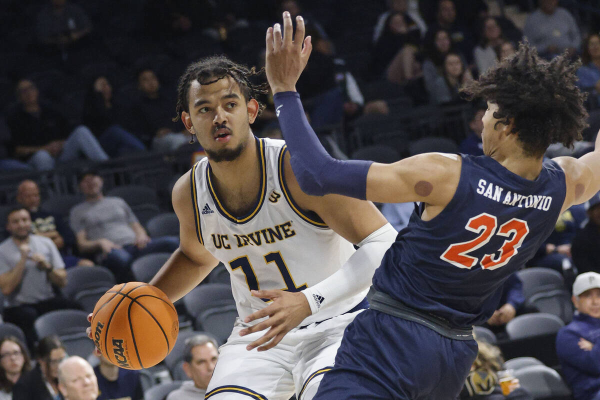 UC Irvine Anteaters forward Devin Tillis (11) tries to drive past Cal State Fullerton Titans gu ...