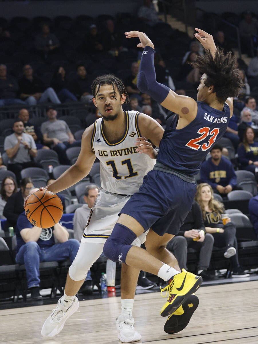 UC Irvine Anteaters forward Devin Tillis (11) tries to drive past Cal State Fullerton Titans gu ...